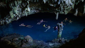 people swimming under the cave of rangko